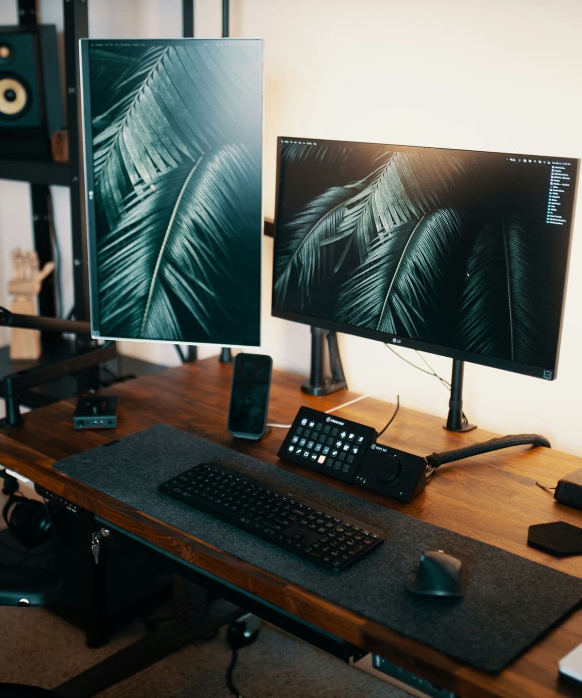 Monitors, keyboard and desk lamp on a wooden desk